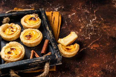 Belem cakes or Pasteis de Belem, Portuguese pastel de Nata Custard Tarts. Dark background. Top view. Copy space.