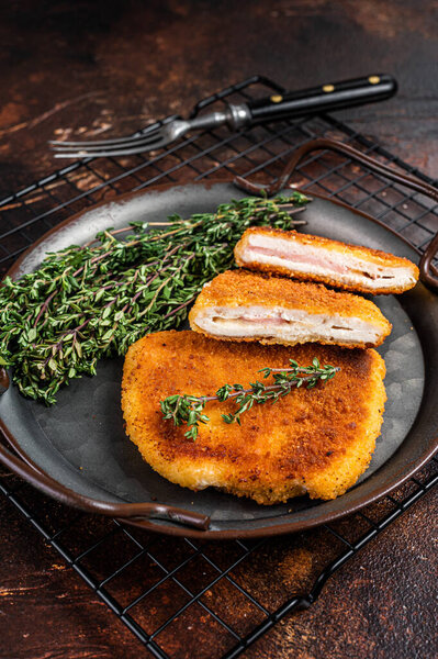 Cordon bleu chicken fillet cutlet with ham and cheese. Dark background. Top view.