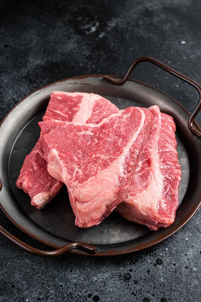 Raw Silverside sirloin beef steak cut on butcher tray. Black background. Top view.