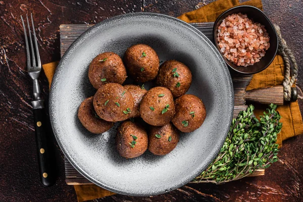 Vegetarian meatless Meatballs from plant based meat with herbs. Dark background. Top view.