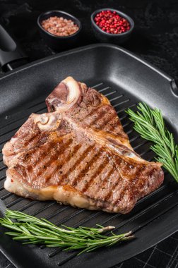 Izgara tavada kızartılmış biftek bifteği var. Siyah arka plan. Üst görünüm.