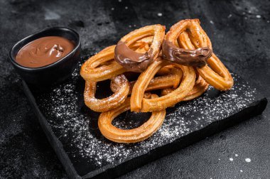Geleneksel Meksika usulü çikolatalı churros. Siyah arka plan. Üst görünüm.