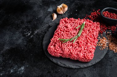 Uncooked beef veal Mince Meat, raw ground meat. Black background. Top view. Space for text.