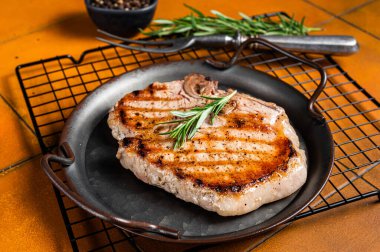Grilled pork T bone chop meat steak. Orange background. Top view.