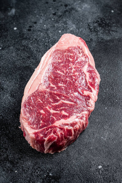 Raw Striploin steak, beef butchery cut. Black background. Top view.