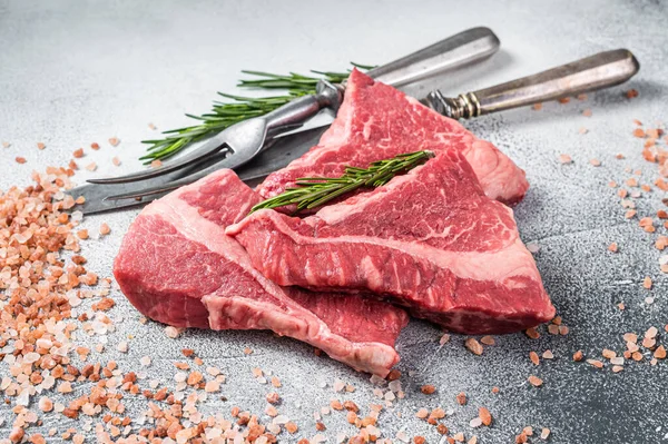 Silverside sirloin beef cut, raw meat on butcher table with herbs. White background. Top view.