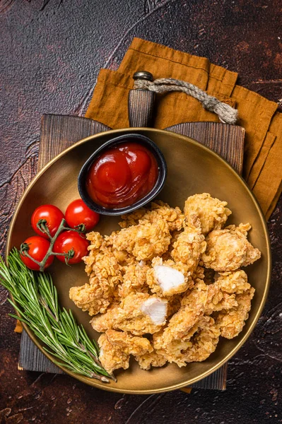 Crispy Popcorn Chicken with Barbecue Sauce in a plate. Dark background. Top view.