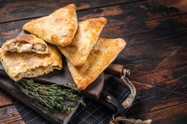 Tavuk ve peynirli fırında samosa, samsa turtası. Ahşap arka plan. Üst Manzara. Boşluğu kopyala.