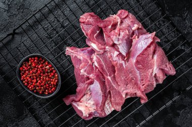 Raw Turkey sliced fillet meat ready for cooking. Black background. Top view.