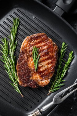 Kızarmış kaburga bifteği, ızgara tavada pirzola eti. Siyah arka plan. en üstteki görünüm.
