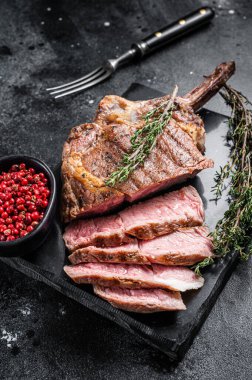 Izgara Tomahawk bifteği, kekikli kaburga. Siyah arka plan. Üst görünüm.
