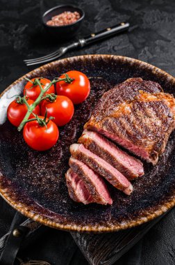 Izgara kaburga bifteği, domatesli pirzola ve mermer et. Siyah arka plan. en üstteki görünüm.