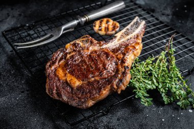 BBQ Grilled Tomahawk or rib eye with bone beef steak. Black background. Top view.