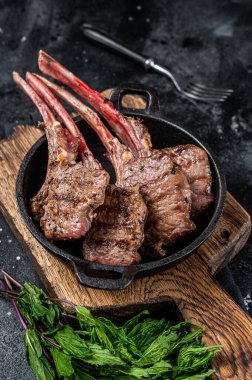 Barbekü ızgara kuzu pirzola, tavada biftek. Siyah arka plan. Üst görünüm.