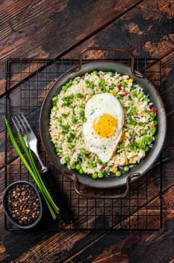 Fried rice with eggs, corn, pea and spice. Wooden background. Top view.