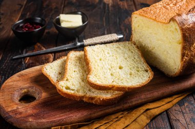 Kahvaltı masasında tereyağı ve reçelli Brioche ekmeği. Ahşap arka plan. Üst görünüm.