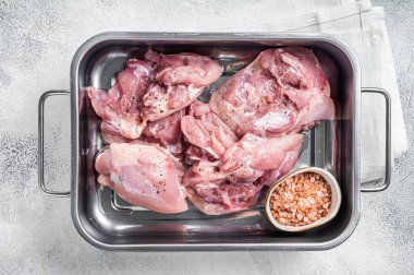 Ready for cooking lamb whole shoulder, raw leg meat on a grill pan with spices. Black background. Top view