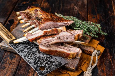 Roast lamb ribs, mutton spareribs, sliced meat on wooden board. Wooden background. Top view.