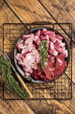 Raw bird giblets meat set, chicken offals, liver, hearts, gizzards Stomach. Wooden background. Top view.