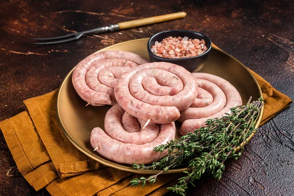 Çiğ domuz sosisi, pişmemiş sosis. Karanlık arka plan. Üst görünüm.
