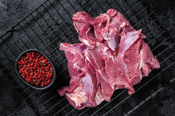 Raw Turkey sliced fillet meat ready for cooking. Black background. Top view.