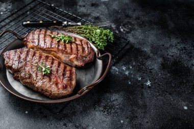 Grilled Top Blade or flat iron beef meat steaks. Black background. Top View. Copy space.