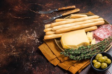 Antipasti aperatifli Grissini ekmek çubukları, salam, zeytin ve parmesan peyniri. Koyu fırın. Üst Manzara. Boşluğu kopyala.