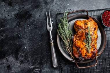 Roasted Glazed Pork meat Roll with thyme and tomato sauce. Black background. Top view. Copy space.