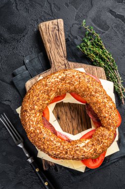 Marul, domates, sarı peynir ve jambonlu simit sandviç. Siyah arka plan. Üst görünüm.