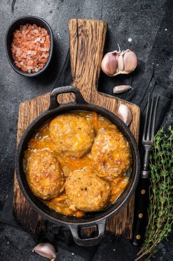 Tavada domates soslu ton balıklı balık köftesi. Siyah arka plan. Üst görünüm.