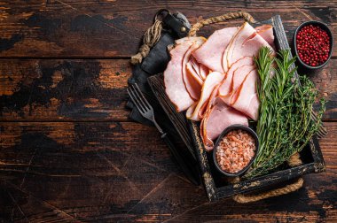 İtalyan Prosciutto Cotto Jambonu ahşap tepside kekik ve biberiyeyle dilimler. Ahşap arka plan. Üst Manzara. Boşluğu kopyala.