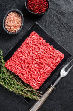 Kekikli taze çiğ kıymalı kıyma. Siyah arka plan. Üst görünüm.