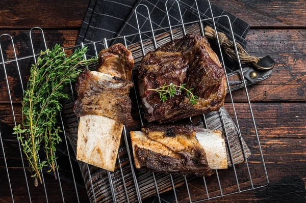 Barbecue chuck beef short ribs on grill. Wooden background. Top view.