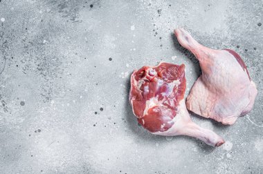 Fresh raw duck legs on a kitchen table. Gray background. Top view. Copy space.