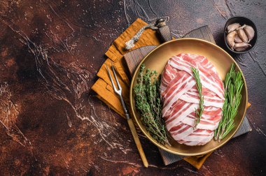 Raw meatloaf with ground beef meat and bacon with herbs and spices, fresh meat loaf. Dark background. Top view. Copy space.