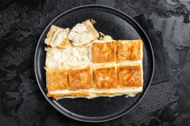 Turkish Su Boregi pie, Tabla borek or burek in plate. Black background. Top view.