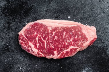 Raw Striploin steak, beef butchery cut. Black background. Top view.