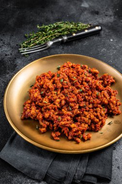 Bolognese sauce with ground beef, stewed with tomato sauce and spices. Black background. Top view.