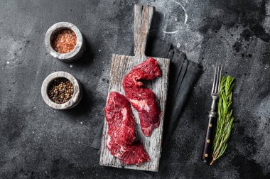 Kanat bifteği çiğ kesilmiş ve tahta tahtada Machete bifteği. Siyah arka plan. Üst görünüm.