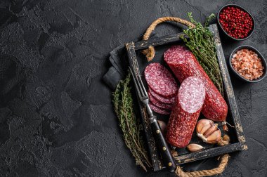 Dilimlenmiş salam sosisi ve taze kekik. Siyah arka plan. Üst Manzara. Boşluğu kopyala.