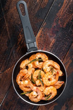 Tavada tereyağı ve sarımsaklı karidesle kızartılmış. Ahşap arka plan. Üst görünüm.