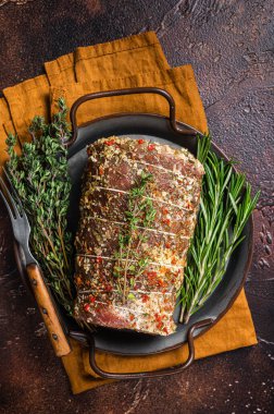 Biberiyeli ve kekikli rulo domuz etli roulade. Karanlık arka plan. Üst görünüm.