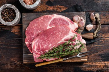 Tahta tahtada çiğ et ve şifalı bitkilerden yapılmış çiğ domuz eti. Ahşap arka plan. Üst görünüm.