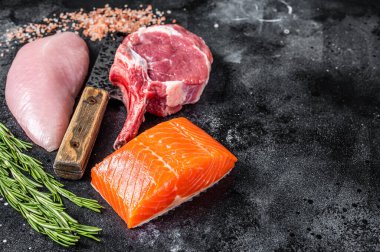 Çiğ biftek - somon, sığır eti ve et satırı üzerinde hindi göğsü fileto. Siyah arka plan. Üst Manzara. Boşluğu kopyala.