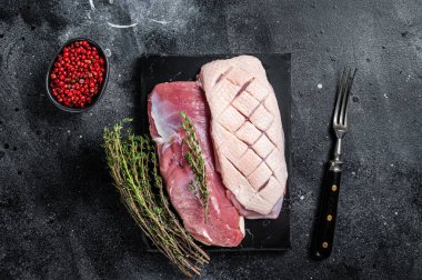 Çiğ ördek göğsü, fileto tavuk eti ve otlu biftek. Siyah arka plan. Üst görünüm.