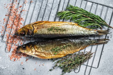 Tütsülenmiş ringa balığı ızgarasında. Gri arka plan. Üst görünüm.