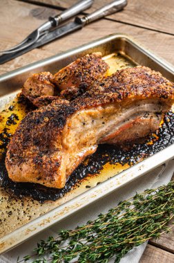 Fırın rosto domuz göbeği, mutfak tepsisinde et. Ahşap arka plan. Üst görünüm.