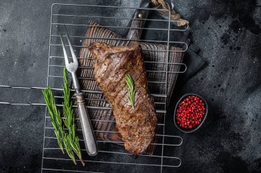 Barbekü ızgarada ızgara biftek. Siyah arka plan. Üst görünüm.