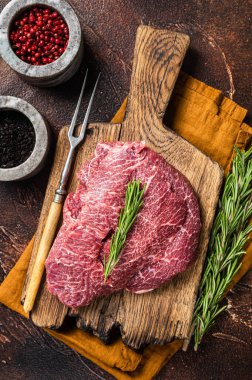 Tahtada pişmemiş çiğ dana eti yanakları. Karanlık arka plan. Üst görünüm.