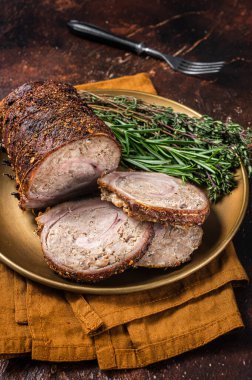 Biberiye ve kekikli bir tabakta kızarmış domuz eti lapası. Karanlık arka plan. Üst görünüm.